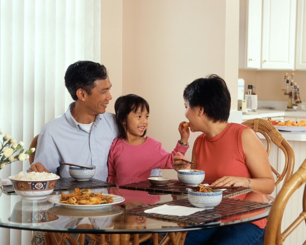 Two adults and a child sharing a meal at a table